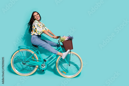Photo of positive optimistic girl wear trendy print clothes enjoying spring holidays empty space isolated on vivid cyan color background © deagreez