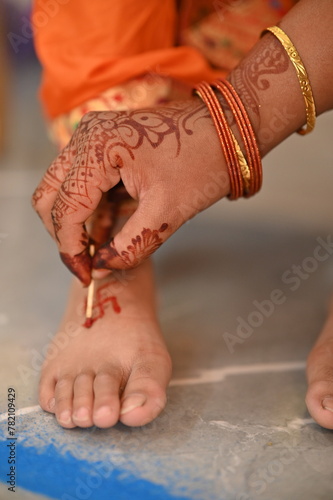 Applying Hindu Swastik on leg. a Swastik As Symbol Of Sun. Hindu Religion. Red ink. Woman indian hand drawing symbol