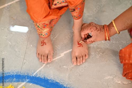 Hand Applying Hindu Swastik on a lag. Swastik As Symbol Of Sun. Hindu Religion. Red ink. Woman indian hand drawing symbol