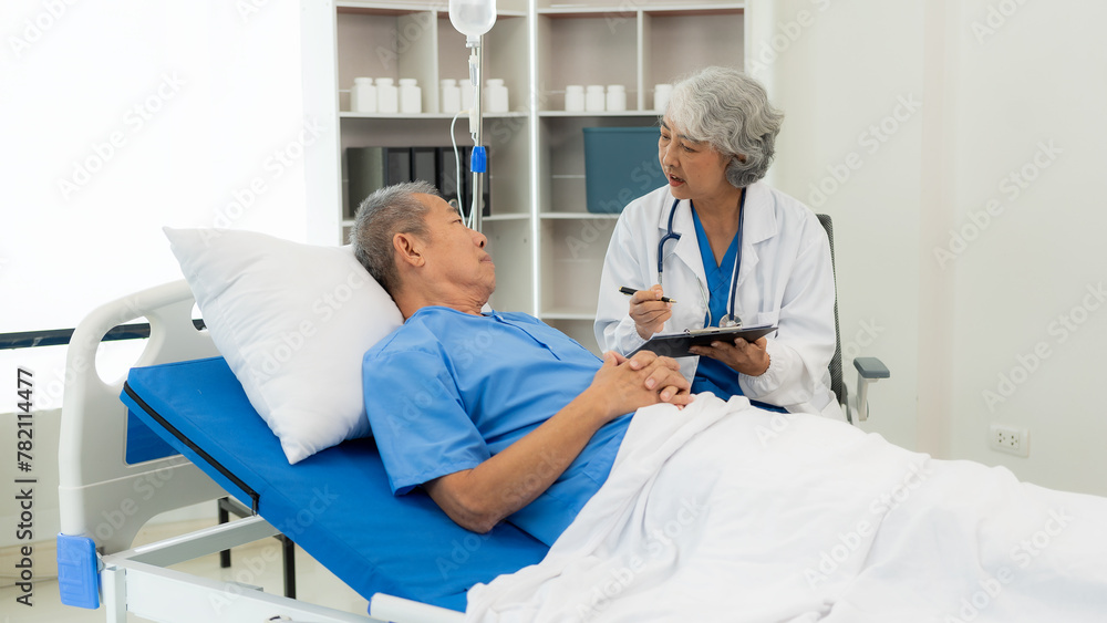 Obraz premium Senior Asian female doctor examining a sick old man in bed, female therapist caring for grandfather in nursing home Health care and health insurance