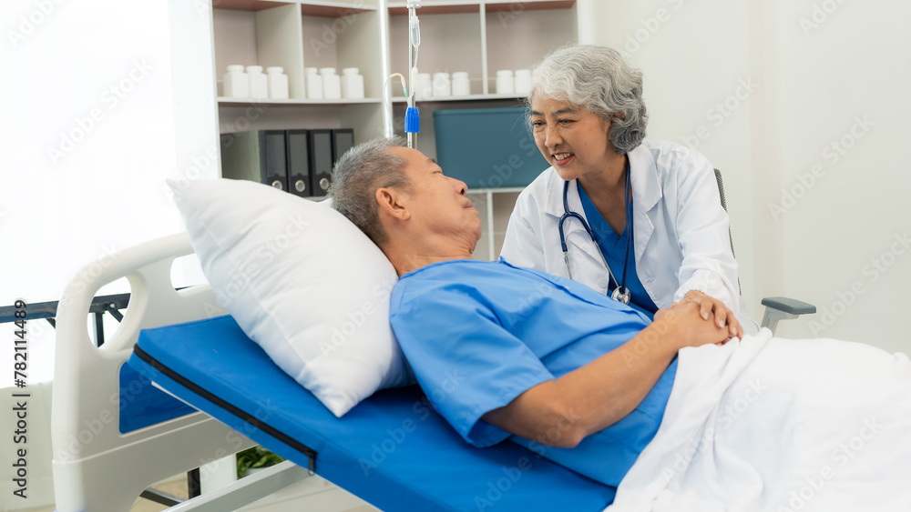 Senior Asian female doctor examining a sick old man in bed, female therapist caring for grandfather in nursing home Health care and health insurance Senior Asian female doctor examining a sick old man in bed, female therapist caring for grandfather in nursing home Health care and health insurance