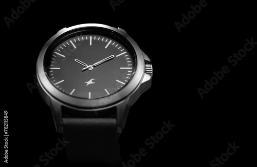 Close up shot of a black and white watch on black background