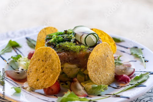 Tuna carpaccio with green caviar and avocado slad served with tortilla chips for lunch at Mediterranean beach restaurant photo