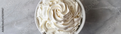 A bowl of cream  whipped to perfection  stands ready to adorn cakes and pastries  its luxurious  velvety whites promising an exquisite finish low noise