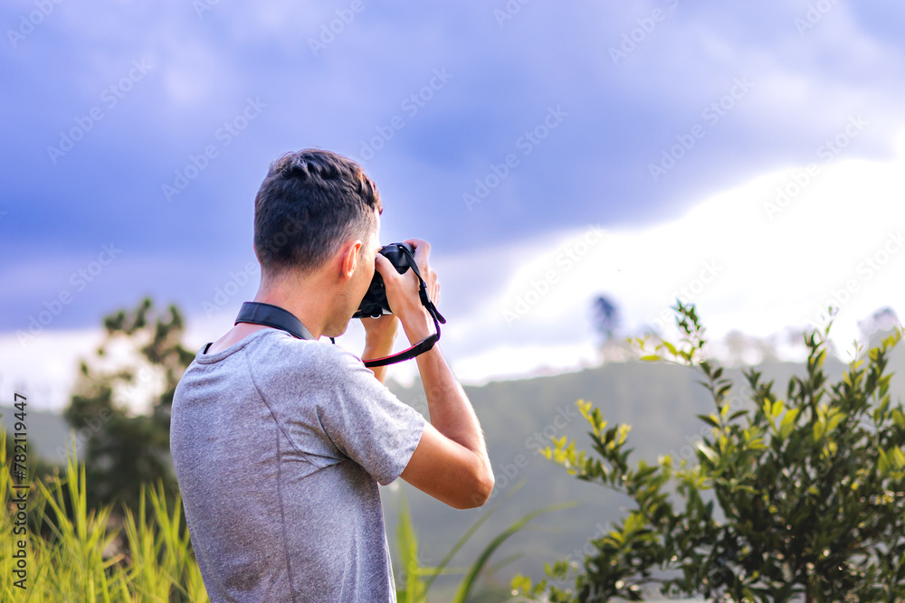 Photographer with camera on a mountain under a cloudy sky. Photographer with camera on a mountain under a cloudy sky.