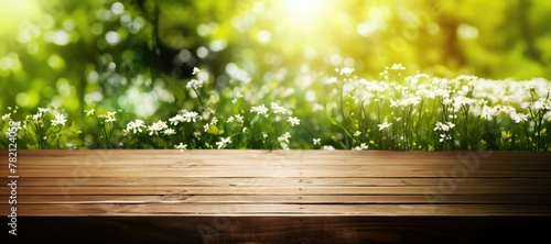 Wooden Table background with free space and blurred landscape and green small leaves.