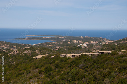 Serene landscape with a green shoreline and blue waters. Capo Ferro, Sardinia, Italy