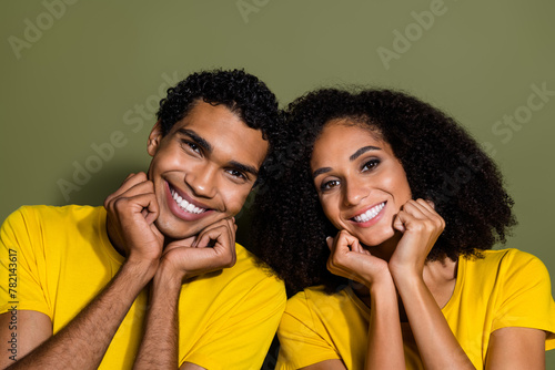 Photo of two young people beaming smile harmony wear t-shirt isolated on khaki color background