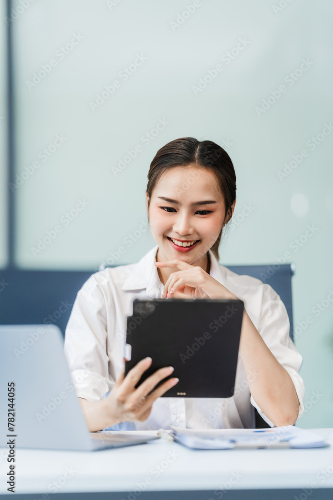 In the office, a businesswoman, accountant by profession, works on financial documents. She uses a computer to calculate income, analyze data, and manage budgets. Asian people. In the office, a businesswoman, accountant by profession, works on financial documents. She uses a computer to calculate income, analyze data, and manage budgets. Asian people.