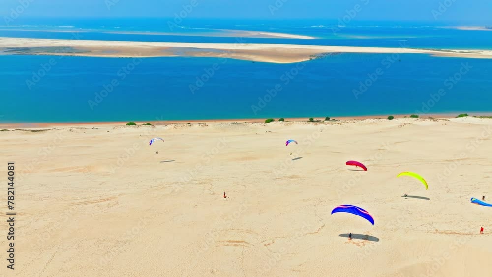 Panoramic view on the tallest sand dune in Europe, a Natural feature in France. Aerial view of tourists enjoying paragliding at the famous Dune of Pilat alongside the shore in France. Panoramic view on the tallest sand dune in Europe, a Natural feature in France. Aerial view of tourists enjoying paragliding at the famous Dune of Pilat alongside the shore in France.
