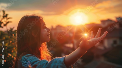 Reaching out to the sun, happy girl at sunset, sunlight shining on her hand, solar system star, happy family concept, touching a dream, asking for help from God