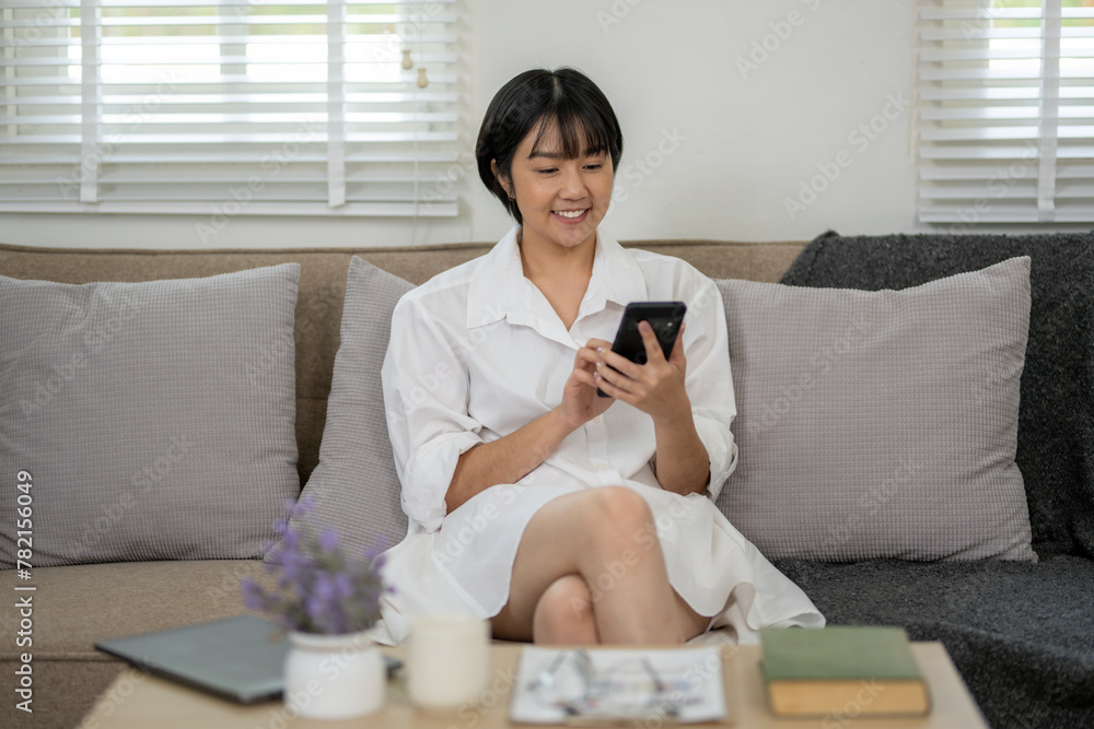 Cheerful businesswoman in white shirt using smartphone with laptop and documents on her office desk.
Cheerful businesswoman in white shirt using smartphone with laptop and documents on her office desk.