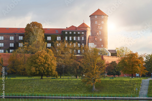 Krakow, Poland. 09.10.2022 Historical Wawel Castle and the Vistula River at dawn in autumn In the warm rays of the sun