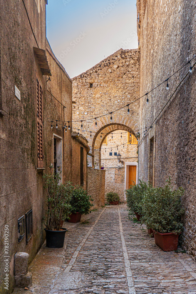Centro storico di Erice, in provincia di Trapani. Piccola strada acciottolata ed edifici residenziali in pietra. Sicilia, Italia.