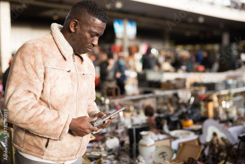 Man looking at used items at a flea market photo