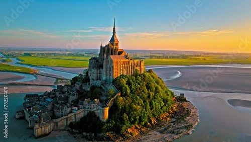 Aerial dramatic sunset over iconic French castle in Europe. Mont Saint-Michel on a tidal island in Normandy, France.