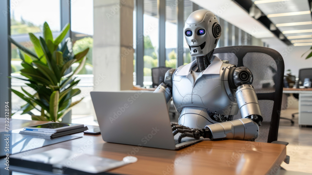 Fototapeta premium Robot Sitting at Desk Using Laptop