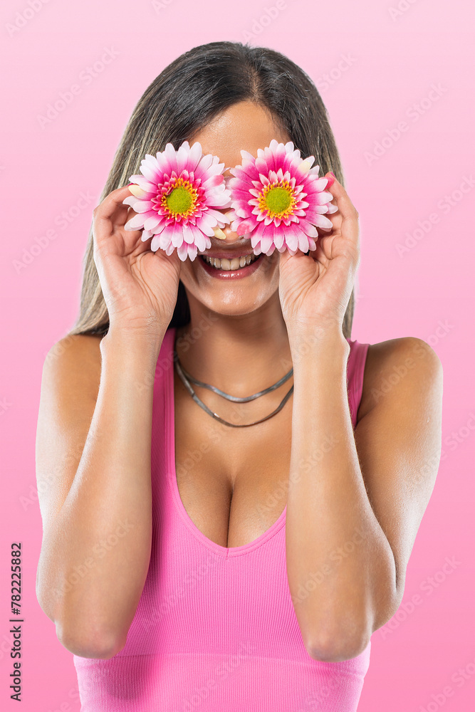 Young woman covering eyes with flowers Young woman covering eyes with flowers