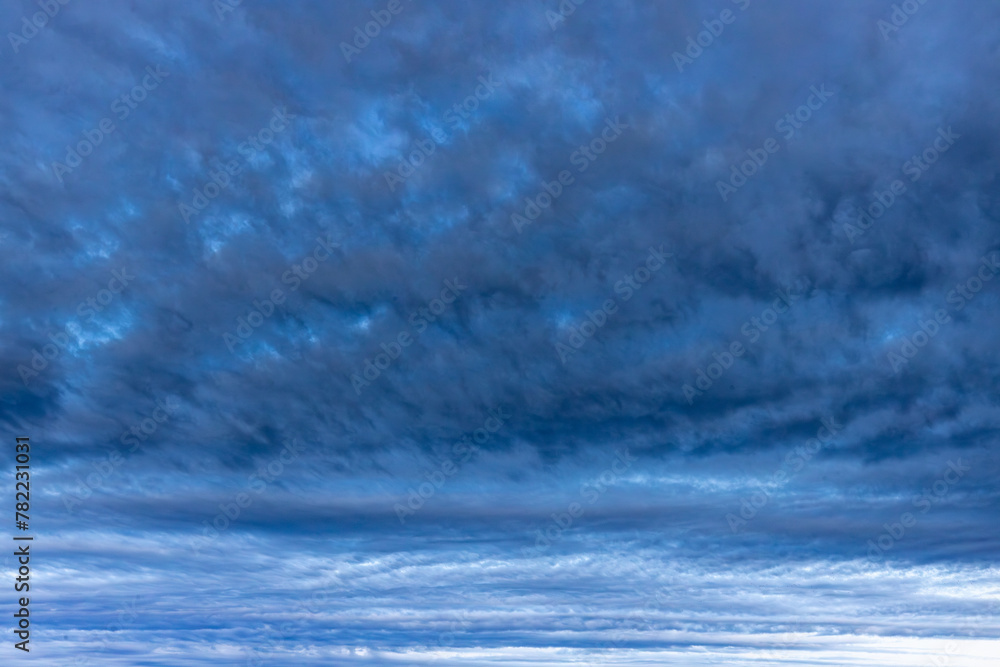 Fototapeta premium Dark rain clouds over sea horizon at sunset