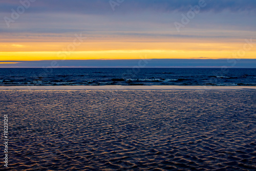 Dark rain clouds over sea horizon at sunset