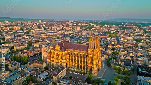 Gothic cathedral with twin towers at golden sunset in France. Reims city situated in a vine-growing country in which champagne wine is produced. Aerial view Cathedral of Notre-Dame of Reims, France. photo