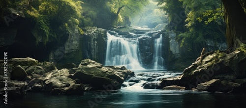 Forest waterfall among boulders and trees