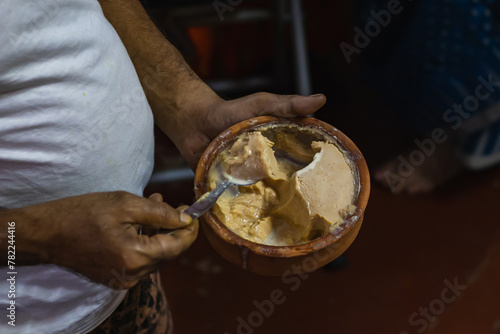 mishti doi or dahi or sweet yogurt being eaten from earthen bowl. This fermented curd is very popular dessert in west bengal, bangladesh & tripura. It is made of milk and jaggery.