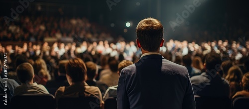 Man leads audience in theatre, attendee engaged in conference