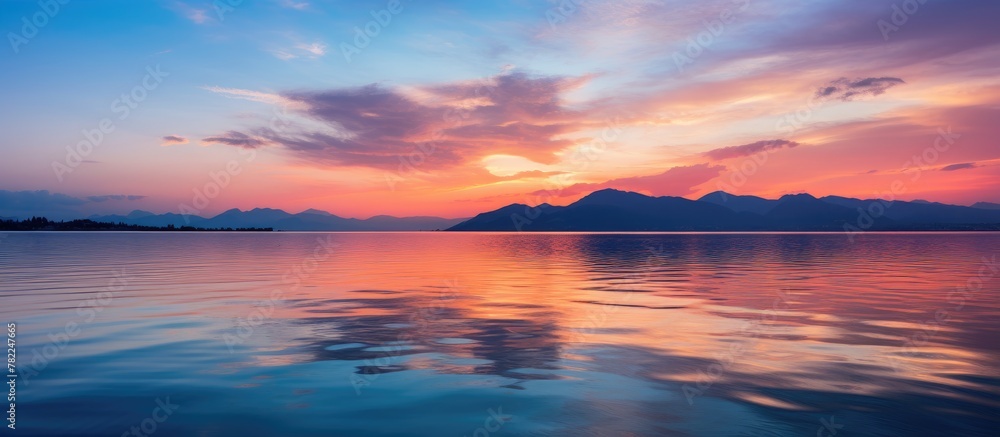 Fototapeta premium Sunset over Water and Mountains