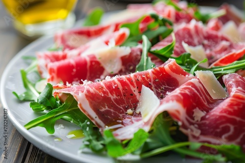  Slices of savory prosciutto ham arranged on a plate with rocket salad, drizzled with olive oil, a simple yet elegant appetizer.