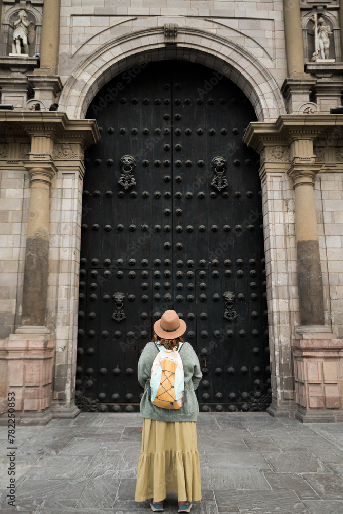 European tourist in front of the gospel door of the Cathedral of Lima.