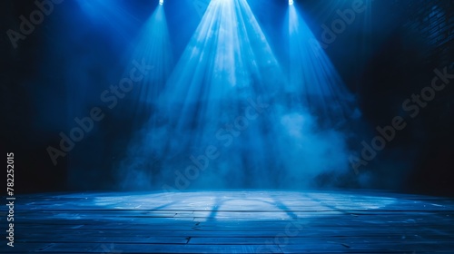Blue spotlights illuminate an empty stage with wooden floor. There is smoke in the air.
