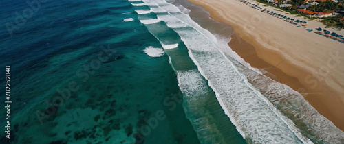 Scenic aerial view of a beach with blue ocean waves crashing on it. Beautiful seascape shot. Atmospheric sea coastal photography header wallpaper illustration concept.
