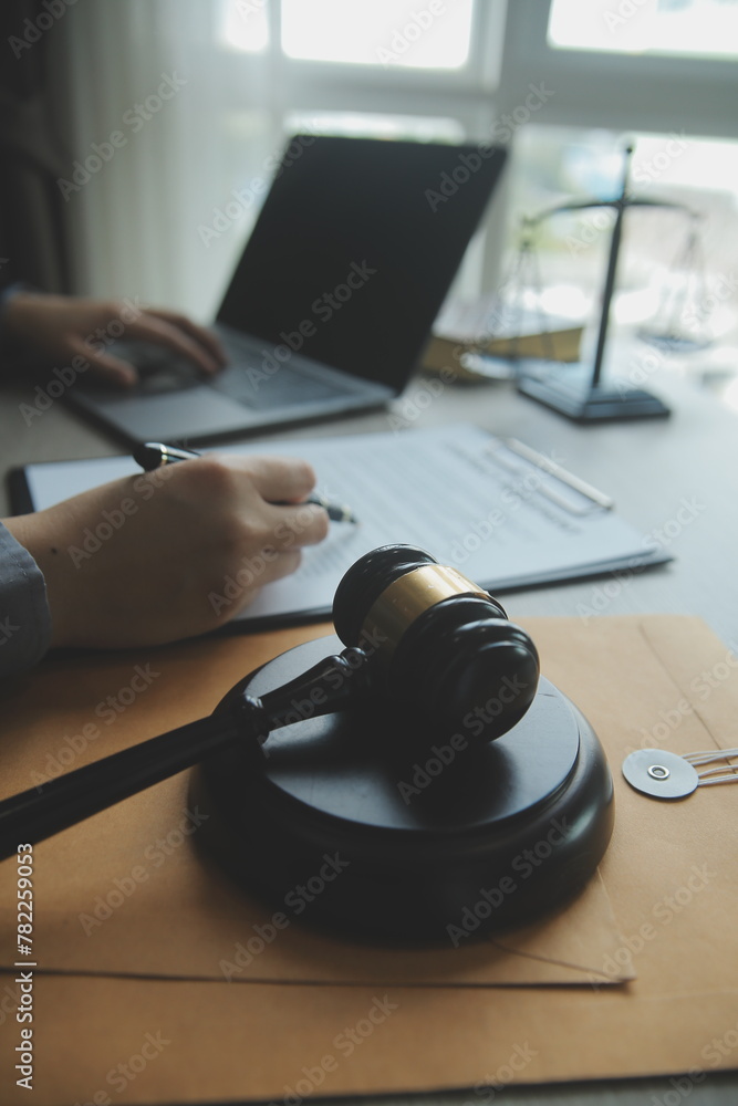 Business and lawyers discussing contract papers with brass scale on desk in office. Law, legal services, advice, justice and law concept picture with film grain effect Business and lawyers discussing contract papers with brass scale on desk in office. Law, legal services, advice, justice and law concept picture with film grain effect
