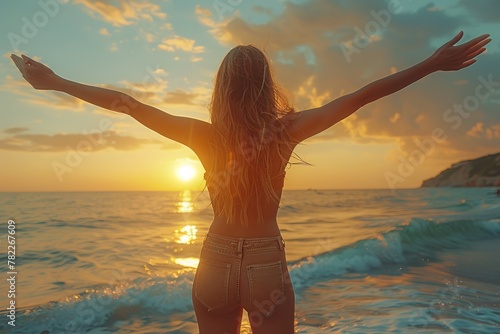 a woman is standing on the beach with her arms outstretched at sunset