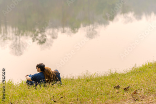 Back view couples sitting and relaxing on river bank enjoy nature atmosphere © Jack Tamrong