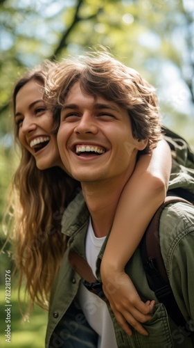 A young couple is laughing and hugging in a forest.
