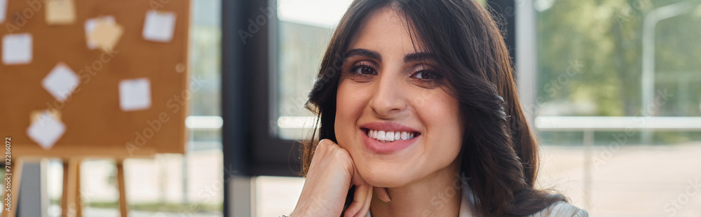 A businesswoman exudes joy as she sits at a table in a modern office, embodying the concept of a thriving franchise. A businesswoman exudes joy as she sits at a table in a modern office, embodying the concept of a thriving franchise.