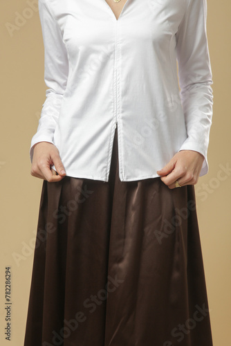 Serie of studio photos of young female model wearing white blouse with brown midi skirt. Comfortable and elegant fashion.