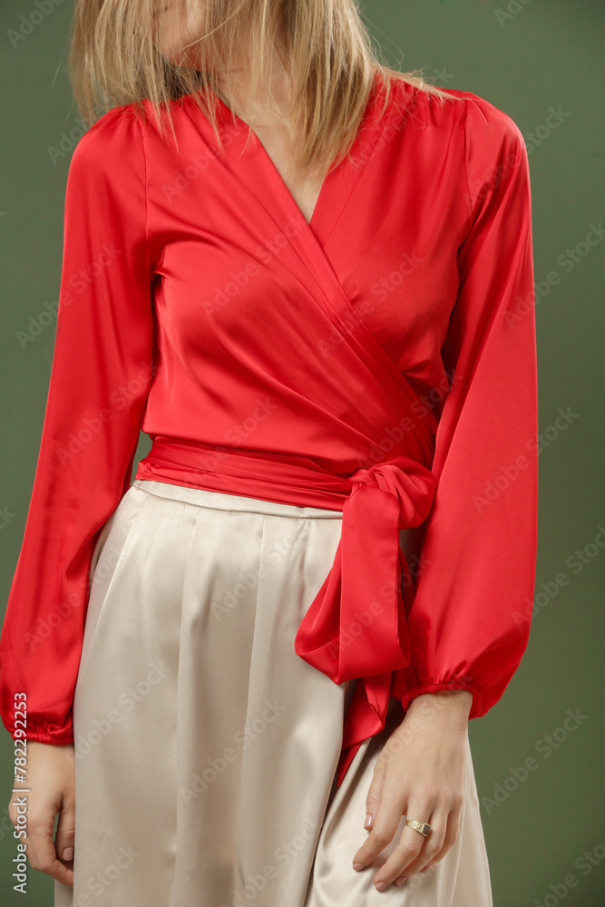 Serie of studio photos of young female model wearing silk satin red blouse with simple beige midi skirt. Comfortable and elegant fashion.