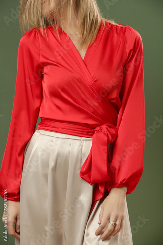 Serie of studio photos of young female model wearing silk satin red blouse with simple beige midi skirt. Comfortable and elegant fashion.
