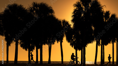 Sunrise in St. Pete Florida with silhouettes walking and biking