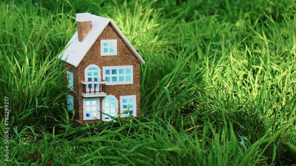 Beautiful brown house among green grass with color-changing light in the windows