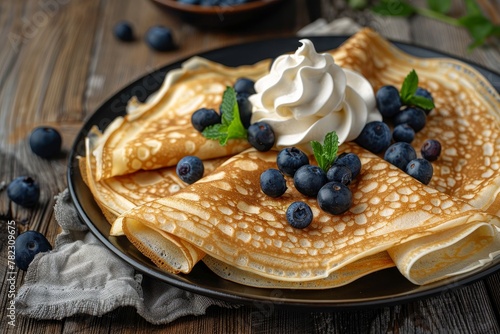 Blueberry crepes with whipped cream on a wooden surface