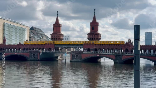 yellow subway train crossing oberbaum Bridge in Berlin, Germany photo