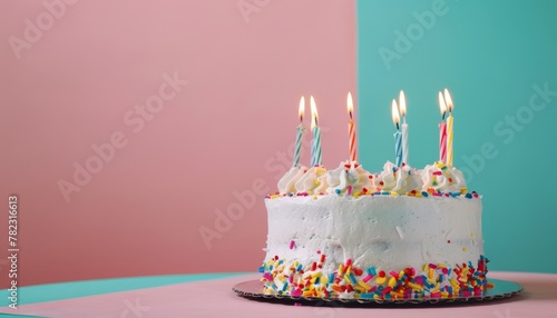 Text space on colorful background with birthday cake and lit candles on a table