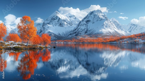   A mountain range mirrors in the tranquil water of a lake Orange trees line the shoreline The backdrop is a blue sky adorned with clouds