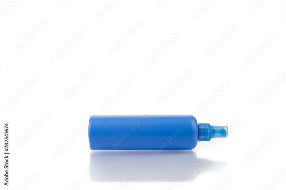 A generic blue plastic hair product or cleaning solution spray bottle with pump sprayer on white with reflection on table A generic blue plastic hair product or cleaning solution spray bottle with pump sprayer on white with reflection on table