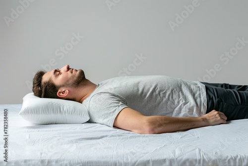 Resting young man with orthopedic pillow on white background Promoting good posture photo