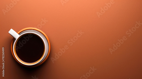 Cup of delicious coffee on plain terracotta colored background, view from above. top view, simple banner with copy space